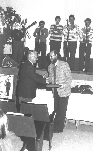 Teyo Moro, presidente de la Asociación Cultural Amigos de las Habaneras, entrega un obsequio al folclorista Joaquín Díaz, homenajeado en la localidad el 31 de noviembre de 1994.