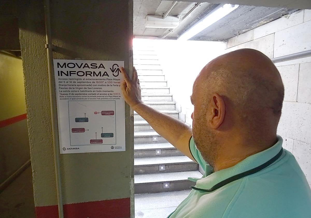 Un trabajador del aparcamiento de la Plaza Mayor coloca el cartel que anuncia el horario de cierre de sus accesos durante las fiestas.