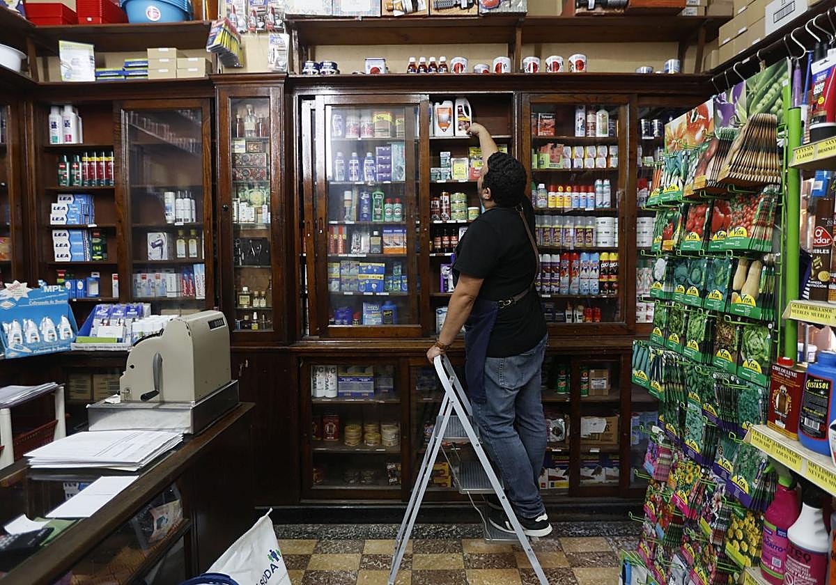Un comerciante coloca productos en su tienda.