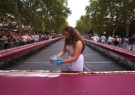 Una pastelera decora la tarta con azúcar impalpable.