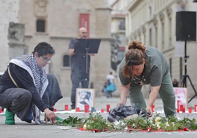 Dos activistas colocan incienso y pintan rayas por cada una de las víctimas mientras, al fondo, Sansón lee algunos de sus nombres en San Pablo.