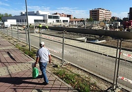 Los operarios rematan las aceras adoquinadas del paseo del Cauce junto al nuevo complejo deportivo.