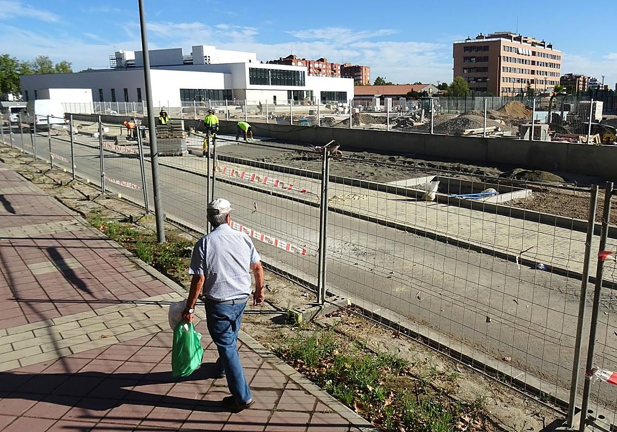 Los operarios rematan las aceras adoquinadas del paseo del Cauce junto al nuevo complejo deportivo.