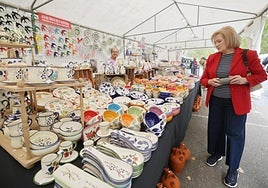 Una mujer observa distintos productos de uno de los expositores de la Feria de Cerámica.