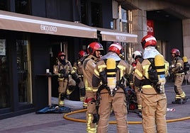 Los bomberos sacan humo del local con un extractor.