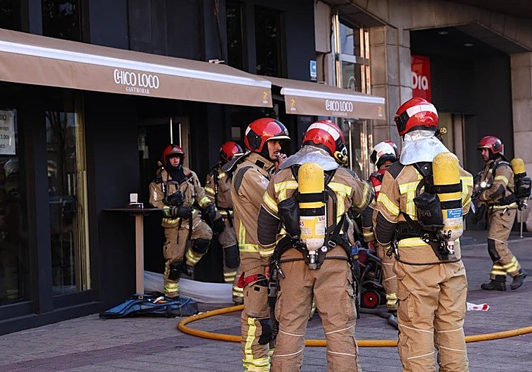 Los bomberos sacan humo del local con un extractor.