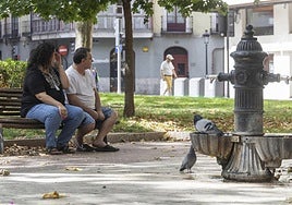 Una pareja en un parque de Valladolid durante la ola de calor de agosto.
