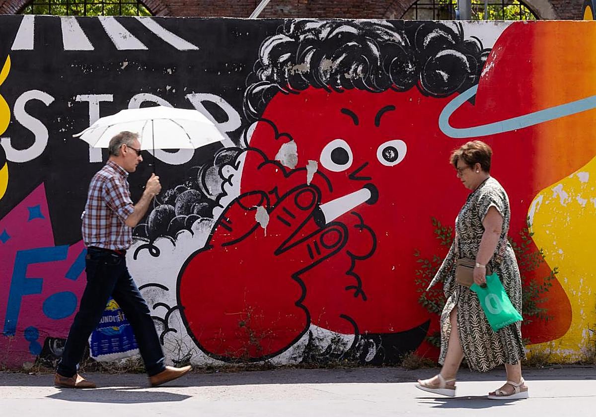 Un hombre se protege del sol durante la ola de calor de agosto.