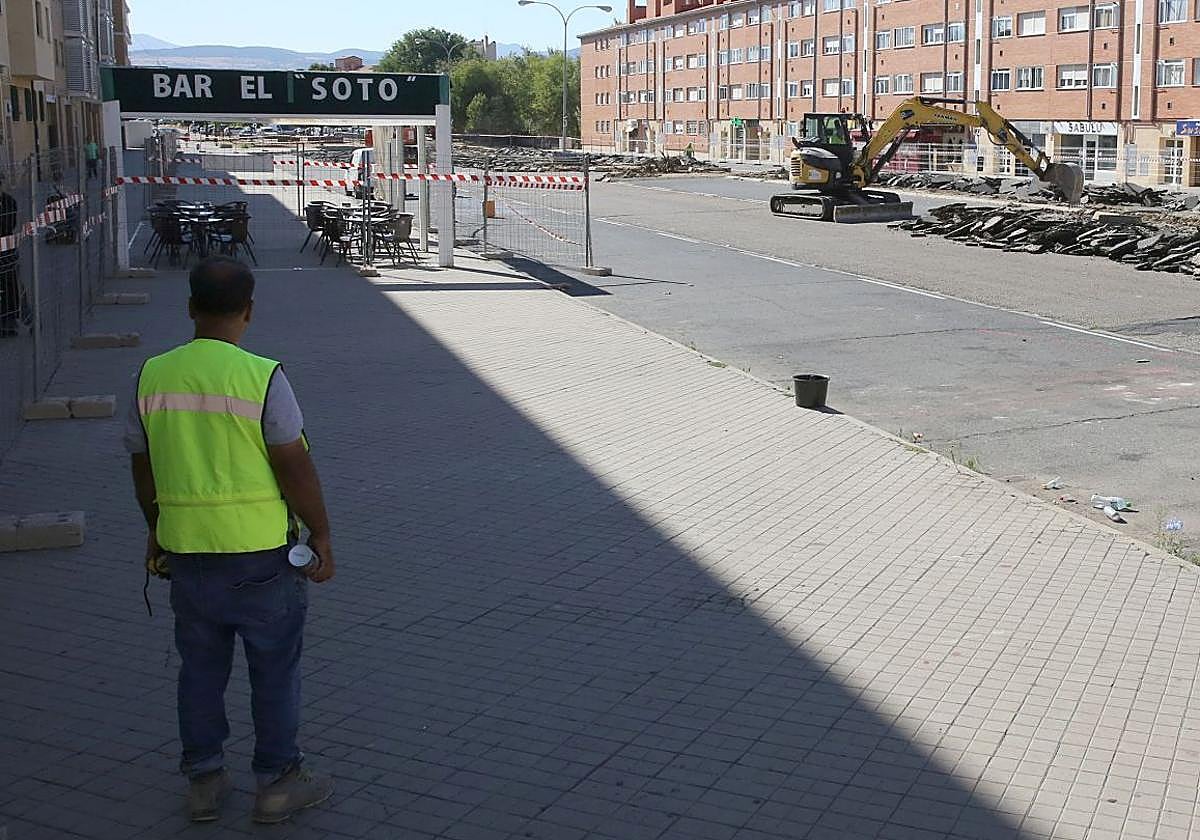 Un operario observa las obras en la plaza de Tirso de Molina junto a la terraza vacía de un bar.