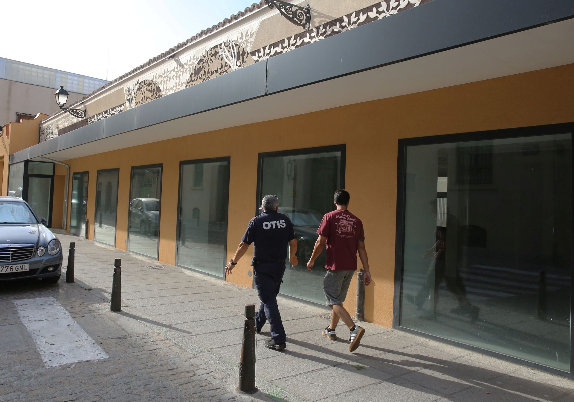 Dos personas caminan junto al mercado de Los Huertos.