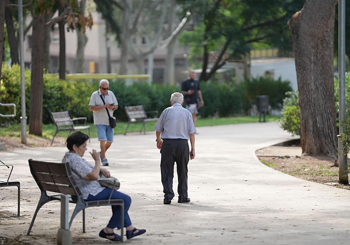 Un jubilado camina por un parque.