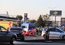 Los sanitarios atienden al motorista sobre el asfalto mientras la Policía Municipal regula el tráfico.