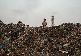 Una niña entre una montaña de escombros y basura en Gaza.