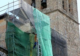 Un operario en el andamio que cubre la fachada principal de la iglesia de San Miguel.