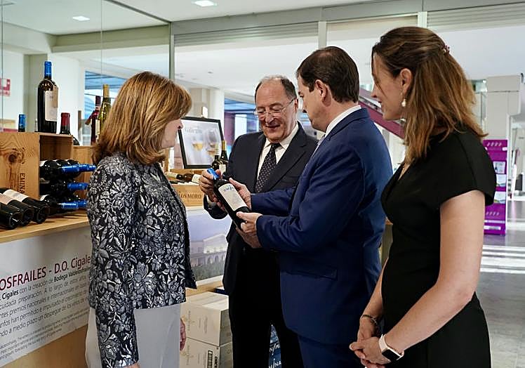 Carlos Moro muestra una botella de Emina a Fernández Mañueco.
