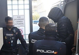 Policías nacionales escoltan a uno de los acusados a su llegada este lunes a la Audiencia de Palencia.