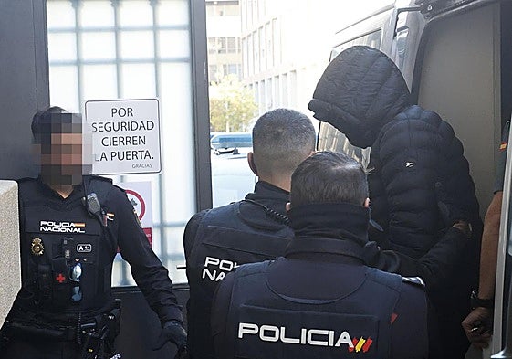 Policías nacionales escoltan a uno de los acusados a su llegada este lunes a la Audiencia de Palencia.
