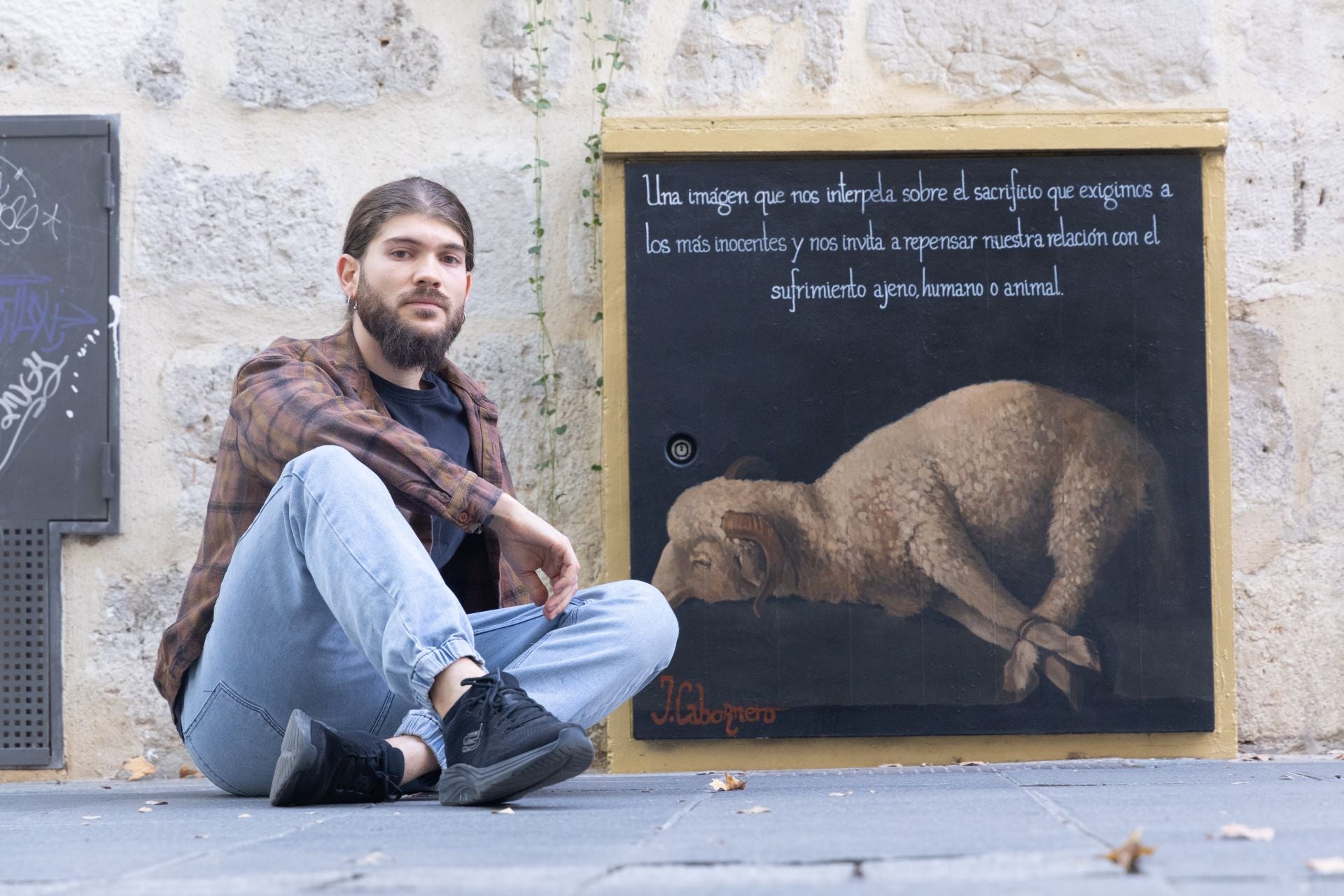 Juan Cabornero con su mural en una caja de registro eléctrico.