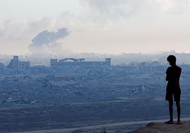 Un niño palestino observa cómo se eleva el humo durante una operación militar israelí en Gaza.