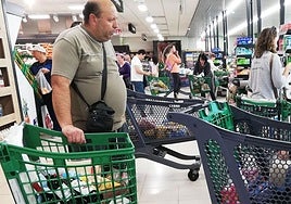 Clientes pasan por caja con sus carritos de la compra en un supermercado de Segovia.