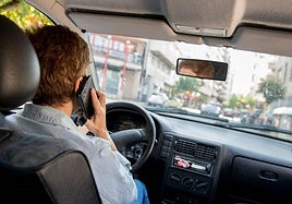Un conductor usar el móvil al volante, en una imagen de archivo.