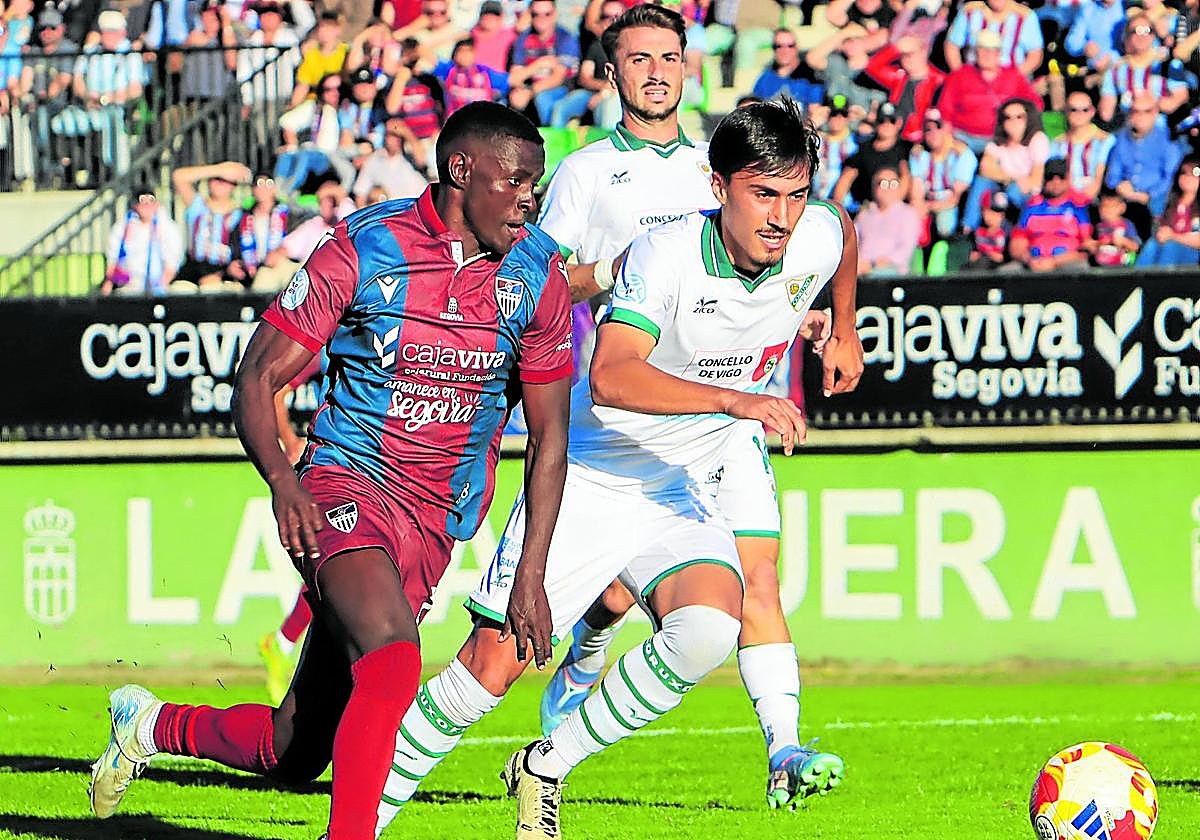 El jugador de la Gimnástica Ayán (izq.) trata de llevarse el balón ante un rival del Coruxo este pasado domingo.