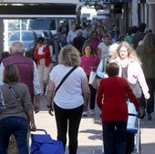 Multitud de personas pasean por una calle comercial de la ciudad de Segovia.