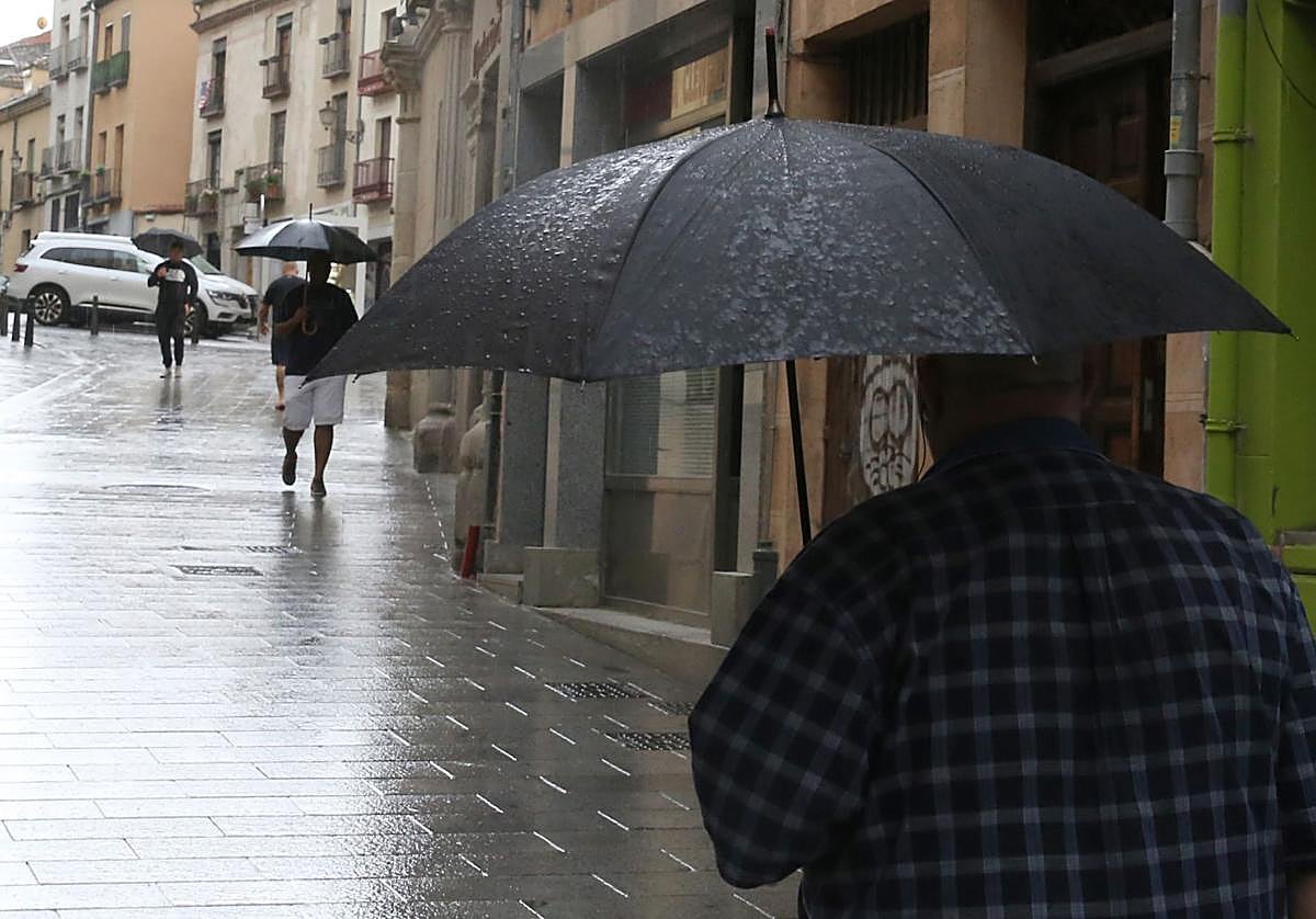 Un viandante se protege de la lluvia en Segovia, en una imagen de archivo.