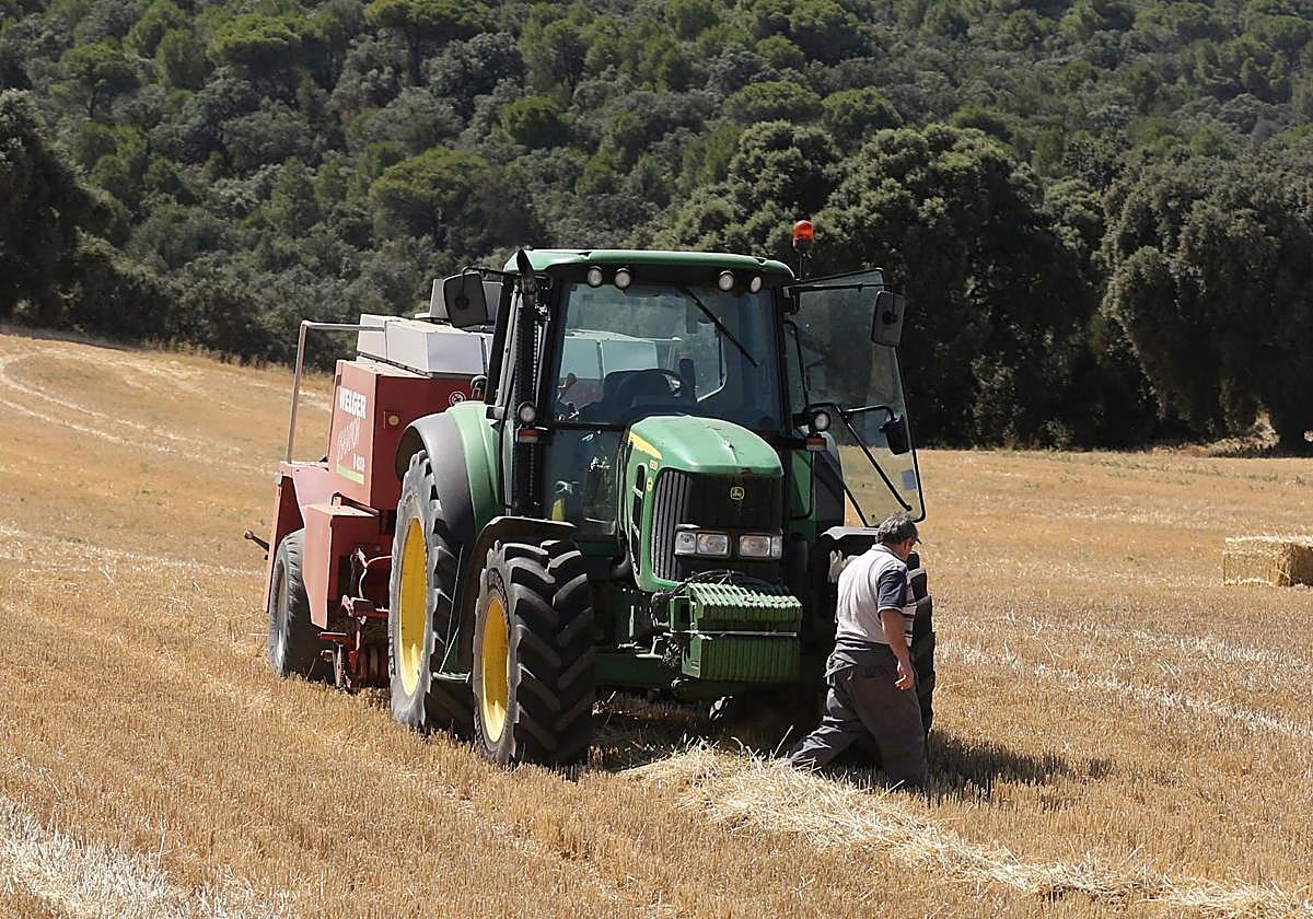 Un agricultor revisa el estado de su vehículo.