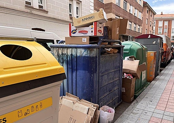 Contenedor azul repleto de cartones en la calle Pedro Romero.