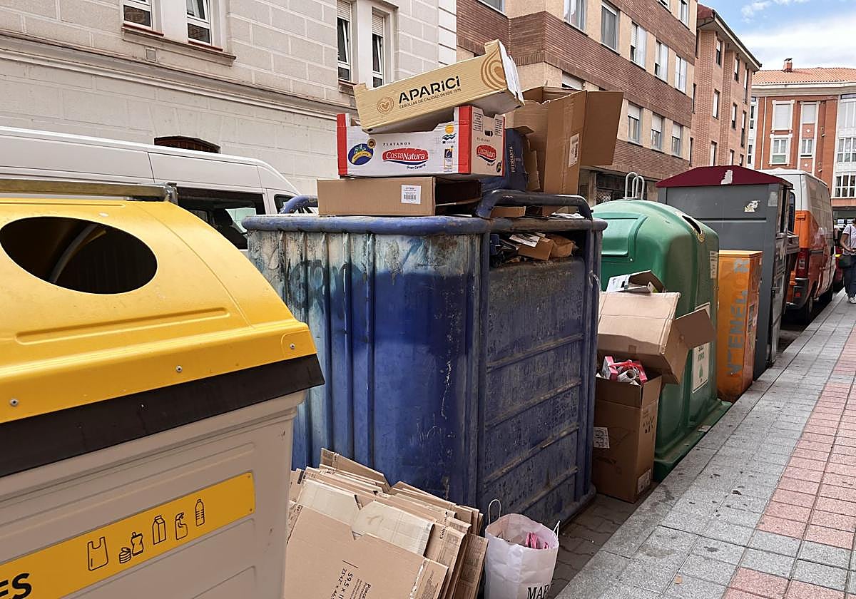 Contenedor azul repleto de cartones en la calle Pedro Romero.