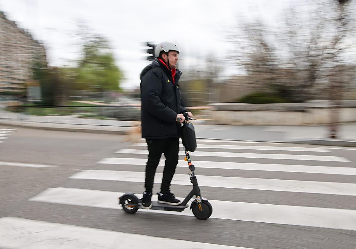 Un usuario de patinete circula por el Puente Mayor.