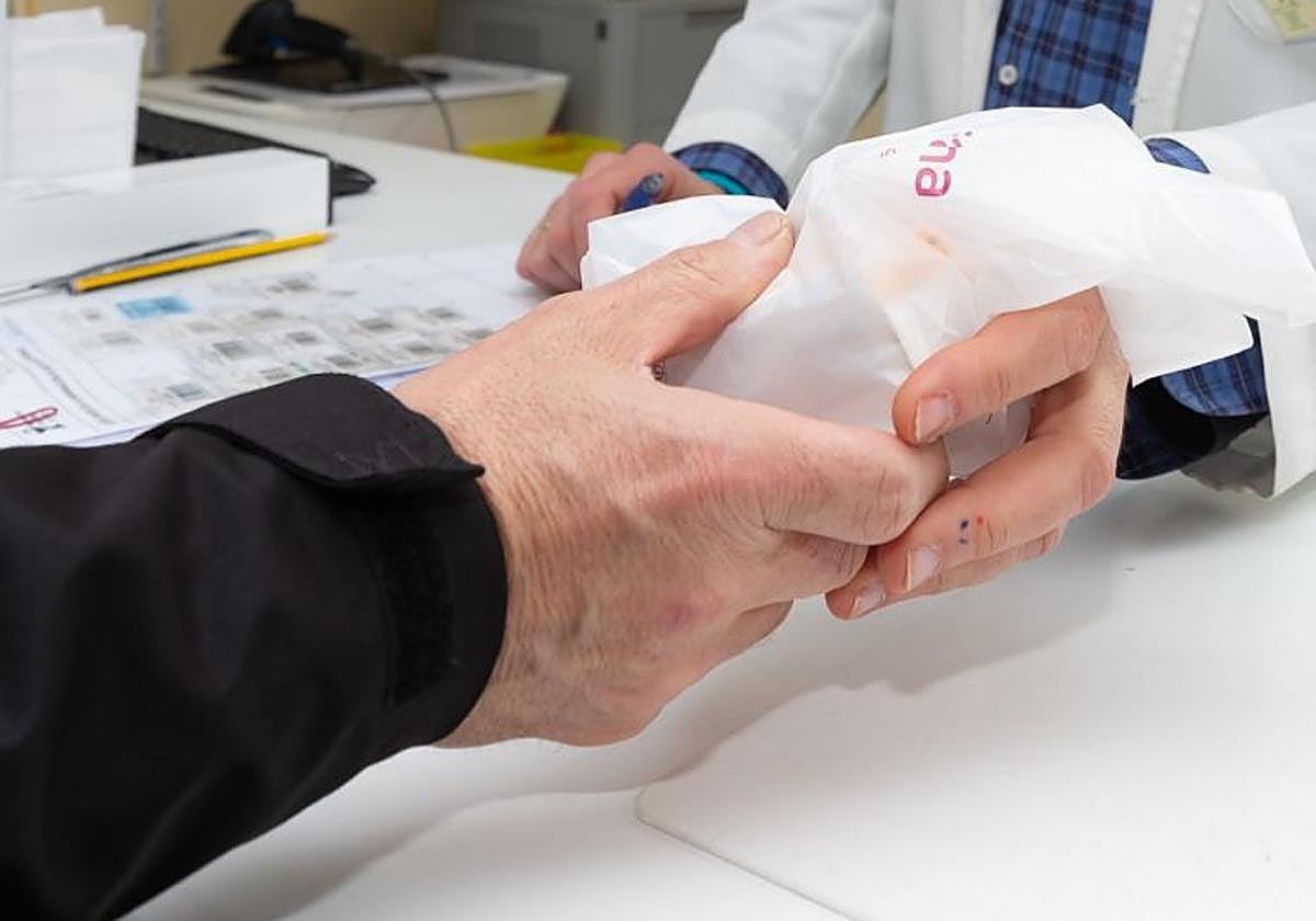 Una persona retira varios medicamentos de una farmacia, en una imagen de archivo.