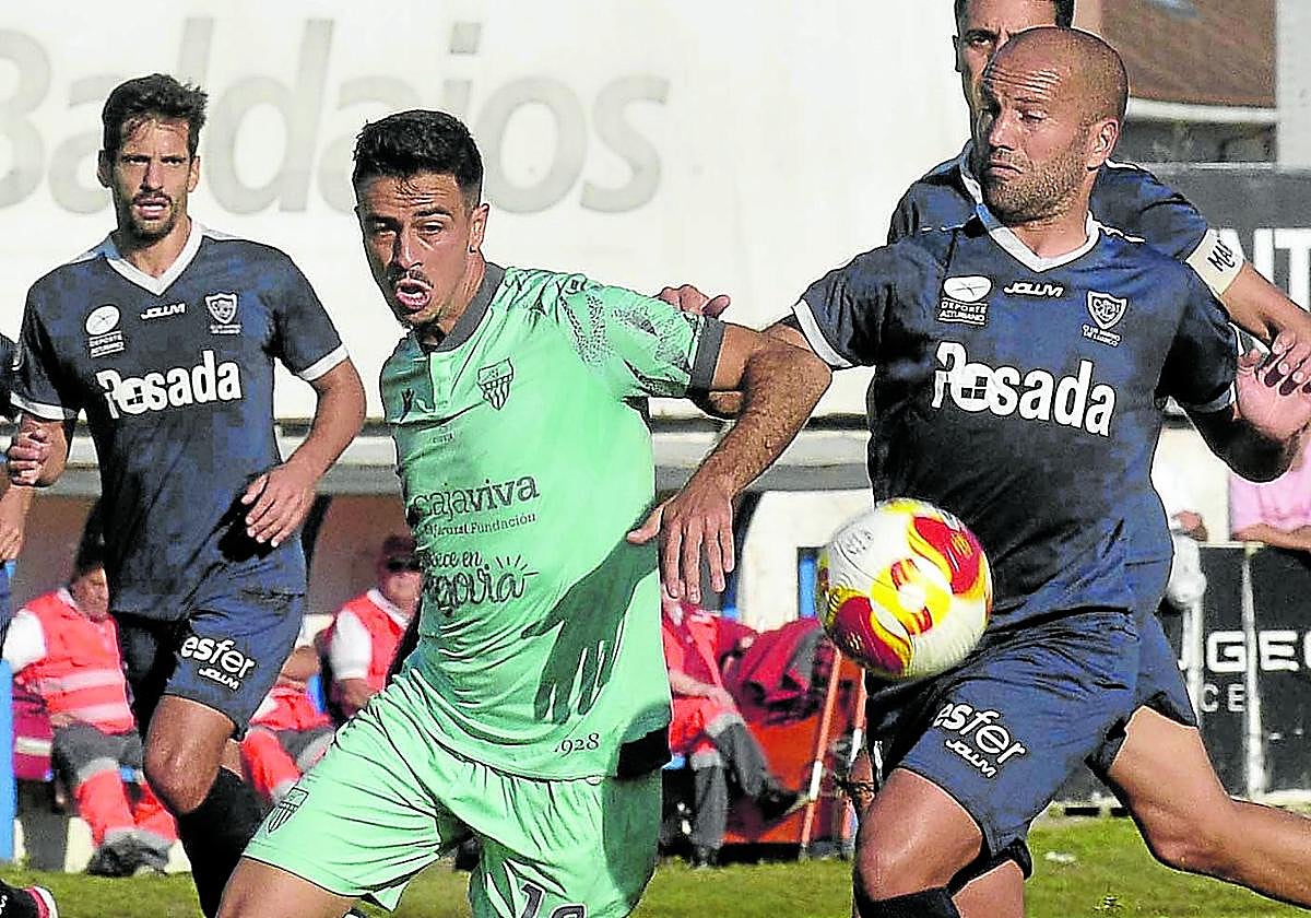 Pugna por la pelota entre un jugador de la Segoviana y dos del Marino de Luanco en el partido de este fin de semana.
