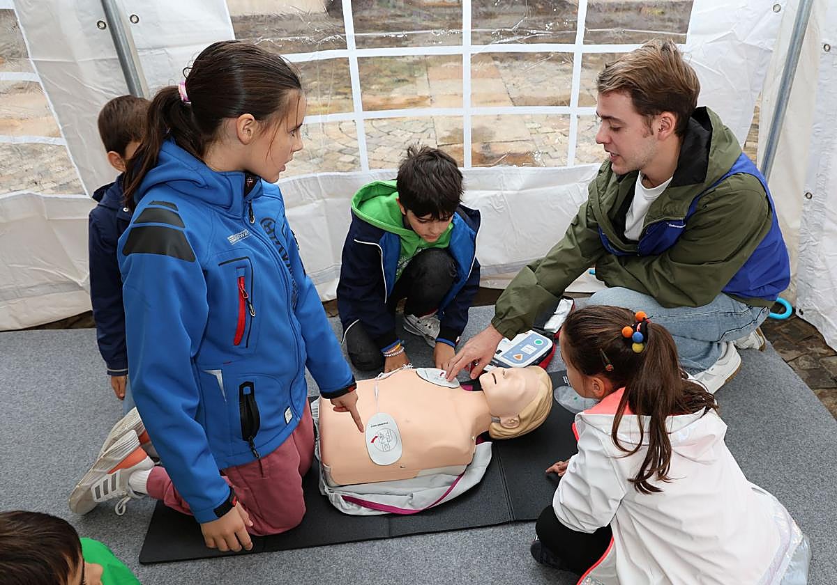Varios niños aprenden a realizar una reanimación cardiopulmonar en un taller