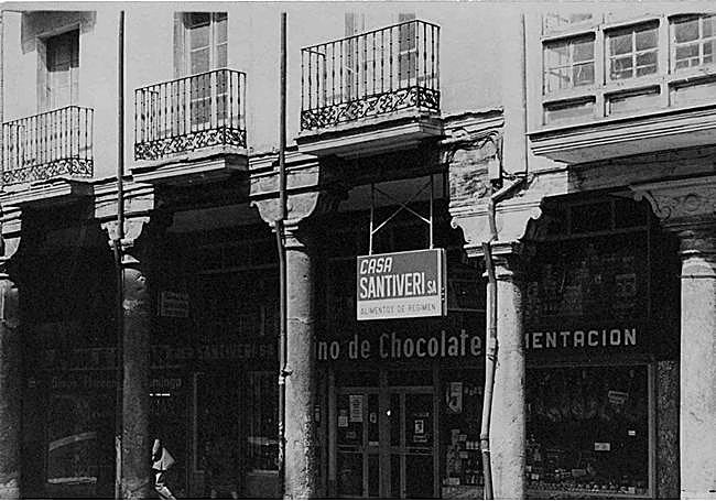 Cartel de Santiveri con el letrero de El molino de chocolate al fondo encima del comercio vallisoletano en los años setenta.
