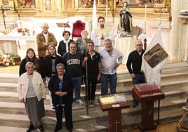 Hermanos de la cofradía, junto a la talla de Santa Teresa.