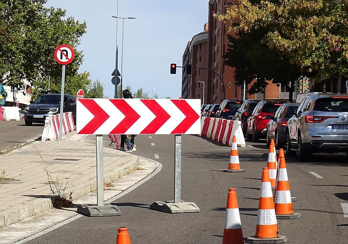 Imagen principal - Arrriba, el embudo en el acceso a Parquesol por Ciudad de la Habana y, debajo a la izquierda, el carril reversible para salir del barrio habilitado en dicha vía. A la derecha, la señal que prohíbe aparcar en la margen de los números impares de Enrique Cubero.