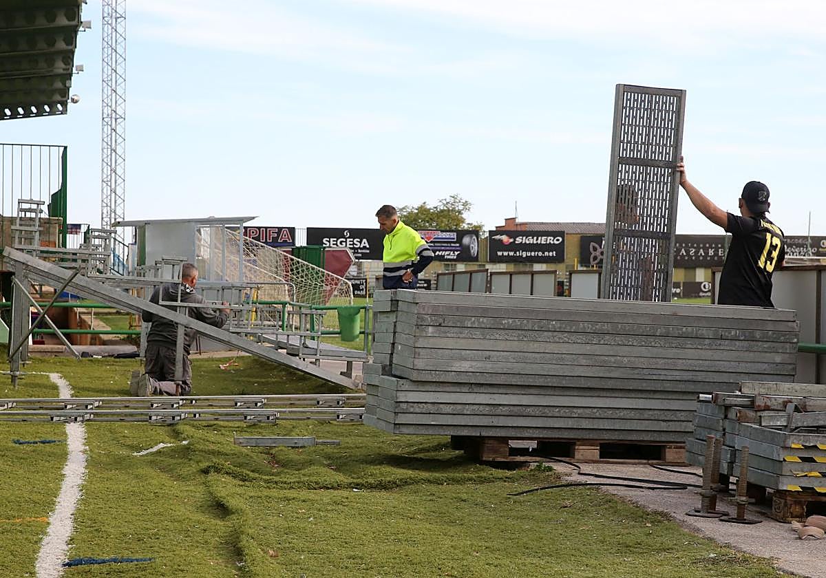 Operarios trabajan en la instalación de las gradas supletorias en el estadio municipal de La Albuera para el partido contra el Ávila.