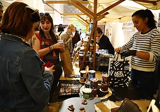 Unas visitantes compran algunos productos en uno de los puestos de la feria