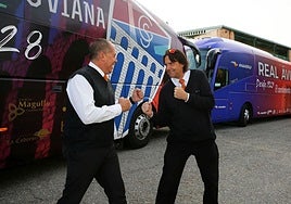 Mariano Herrero y Moisés Veguillas simulan la rivalidad de la Segoviana y el Real Ávila ante los autobuses de los equipos que conducen.
