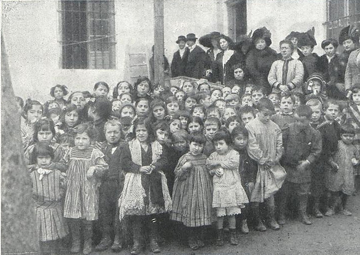 Imagen secundaria 1 - Arriba, Teófila Díez sentada mientras era homenajeada en enero de 1931. Abajo, niños de un comedor escolar en 1912 y el palacio de Fabio Nelli, donde se inauguró la primera cantina escolar en noviembre de 1908.