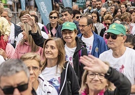Participantes en la marcha contra el cáncer de este domingo en Segovia saludan al inicio del recorrido.