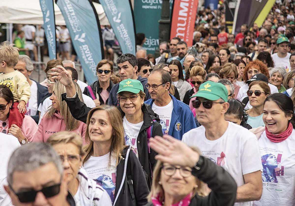 Participantes en la marcha contra el cáncer de este domingo en Segovia saludan al inicio del recorrido.