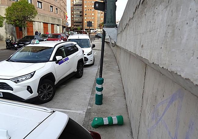 Detalle del bolardo derribado bajo una de las bases de las farolas que sobresalen del lateral del viaducto tras la parada de taxis.