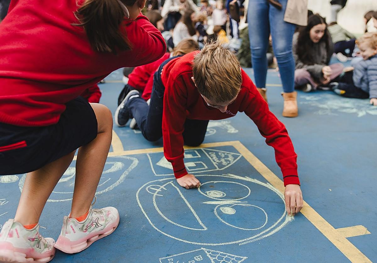 Alumnos de La Salle dibujan sobre el suelo del patio.
