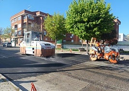 Dos máquinas trabajan en el asfaltado de un paso de peatones elevado.