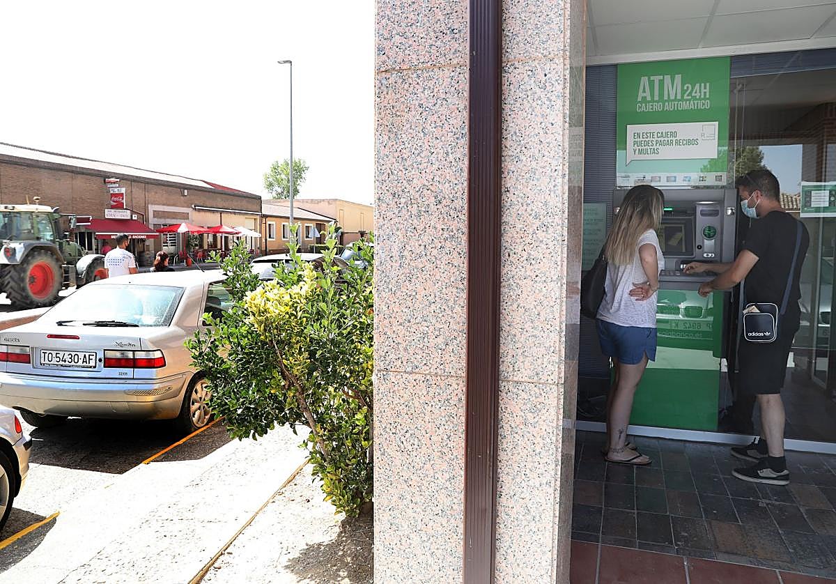 Dos personas realizan una operación en el cajero automático de Frómista.