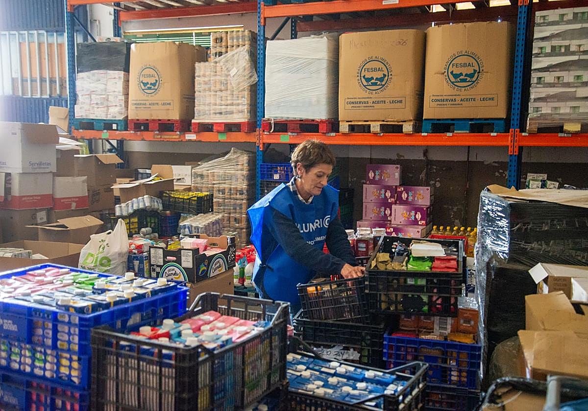 La secretaria del Banco de Alimentos, Rosa Ortega, organiza la comida para los usuarios en la sede de la entidad.