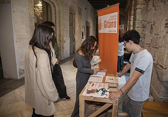 Varios alumnos consultan la información de uno de los estand.